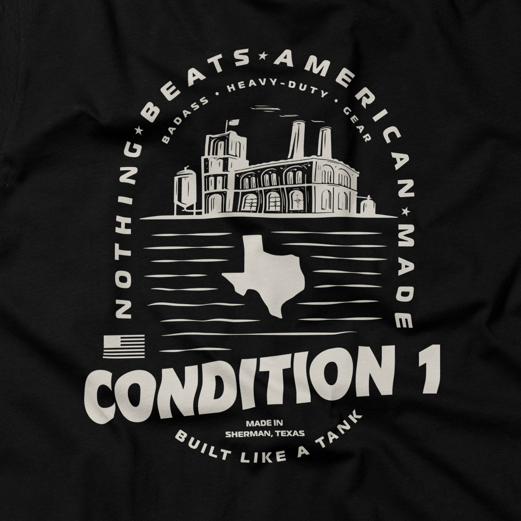 Black American-made T-shirt featuring a white graphic of a factory, Texas outline, and text emphasizing quality and durability.