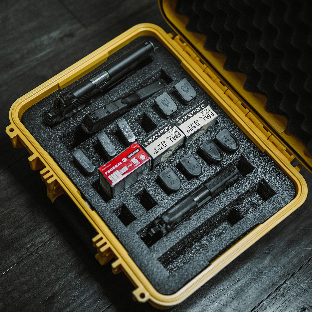 Yellow protective case with a black foam insert, designed for organizing 4 slots for firearm accessories or tools.