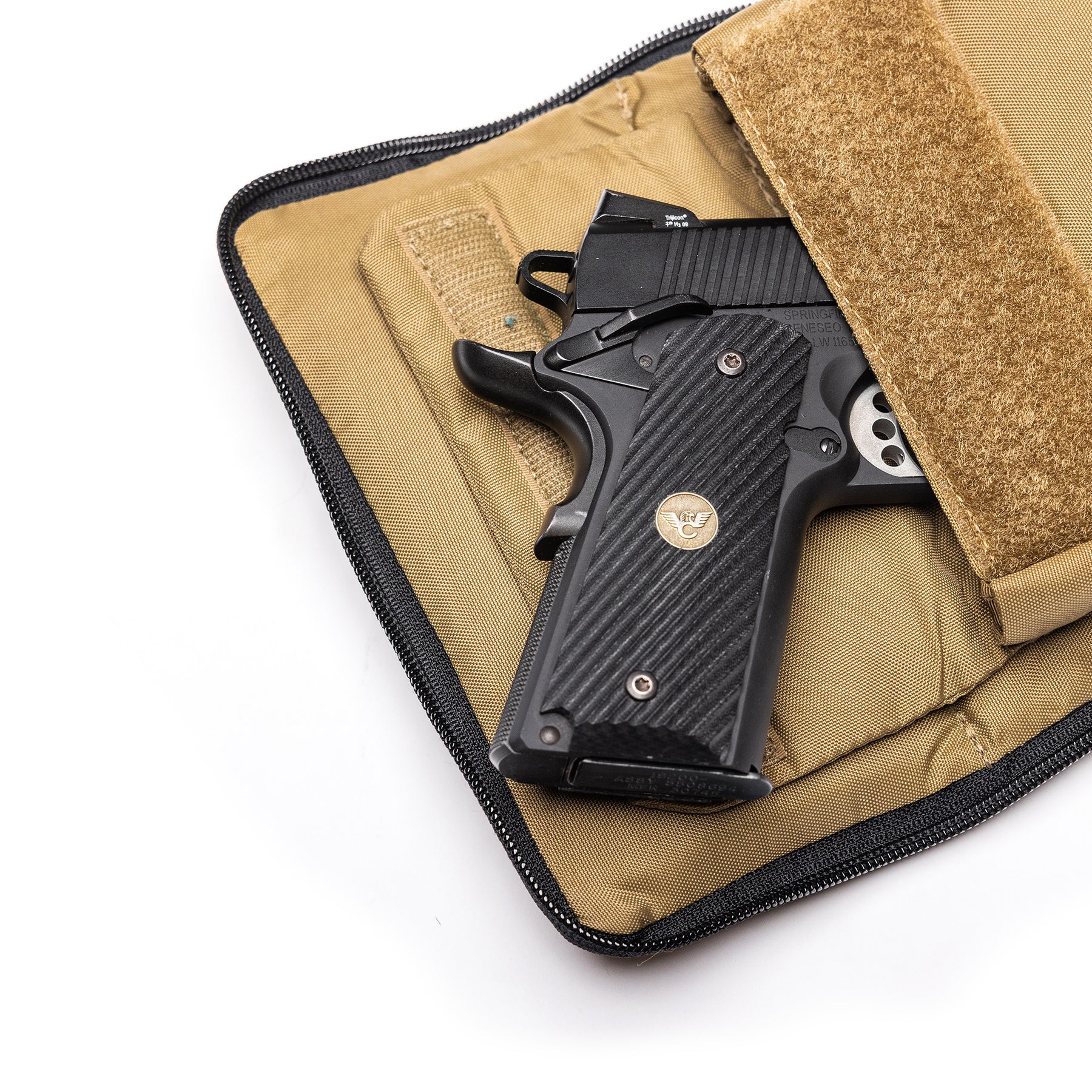 Black Lone Star 2 pistol bag with a textured grip, partially open, inside a tan protective case with a Velcro strap.