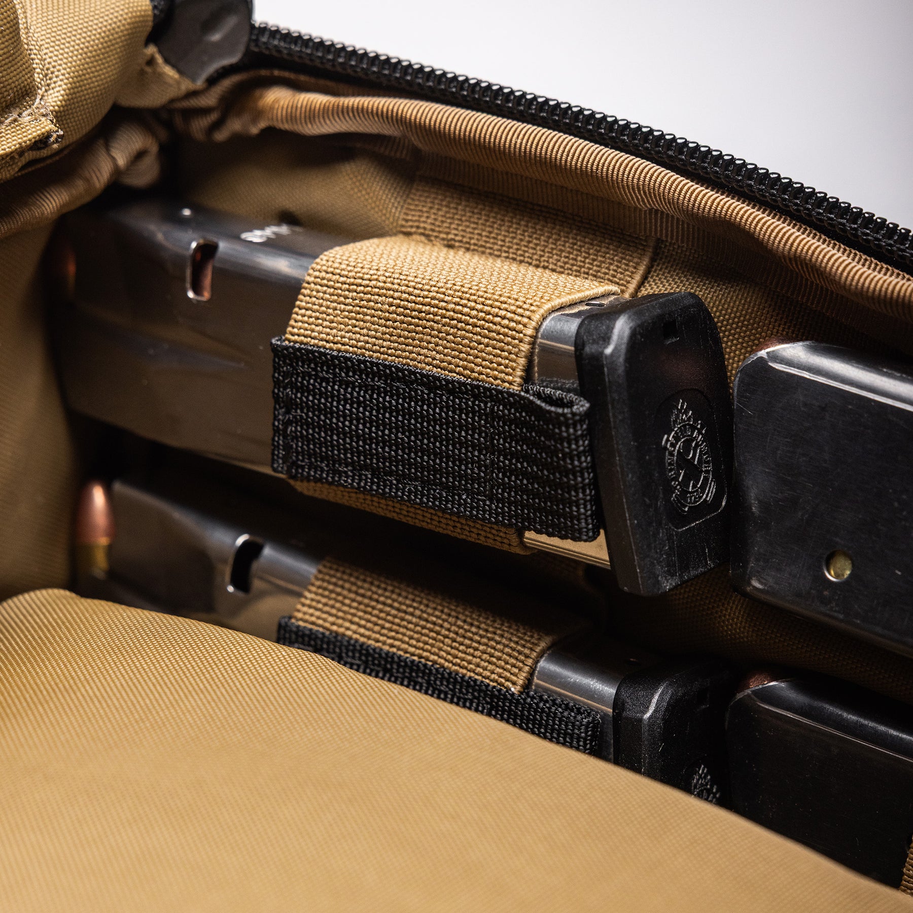 Close-up of the Lone Star 2 Pistol Bag with two pistols secured inside, featuring tan and black straps and padded interior.