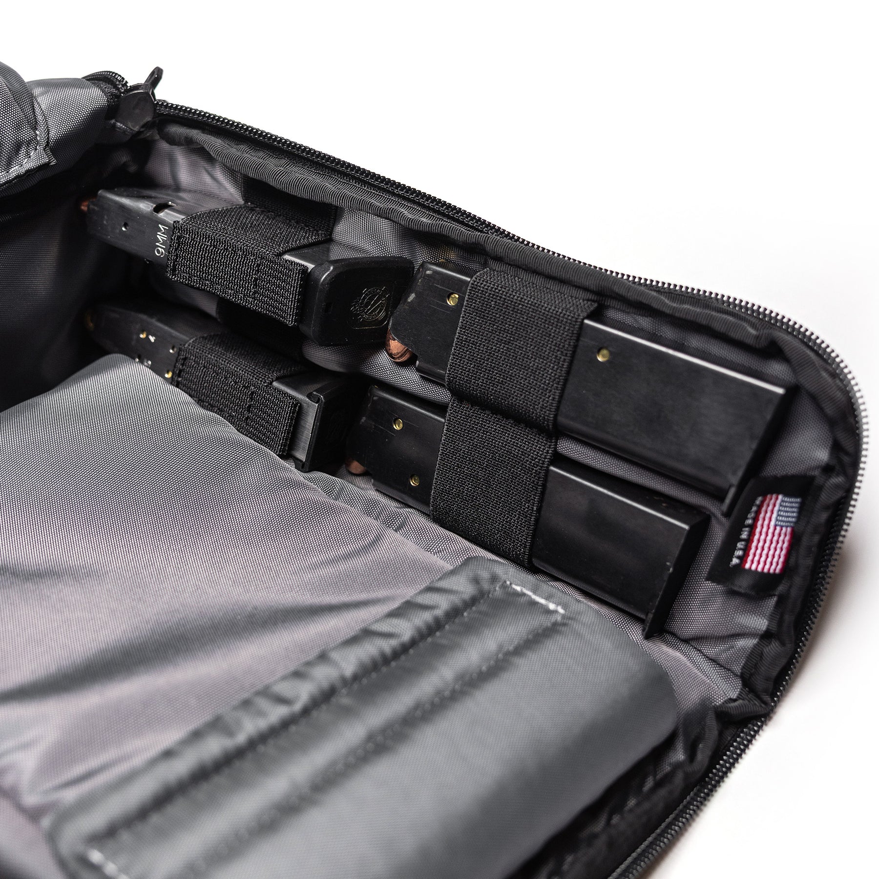 Inside of a Lone Star 2 Pistol Bag showing multiple black pistol magazines secured with elastic straps and compartments.