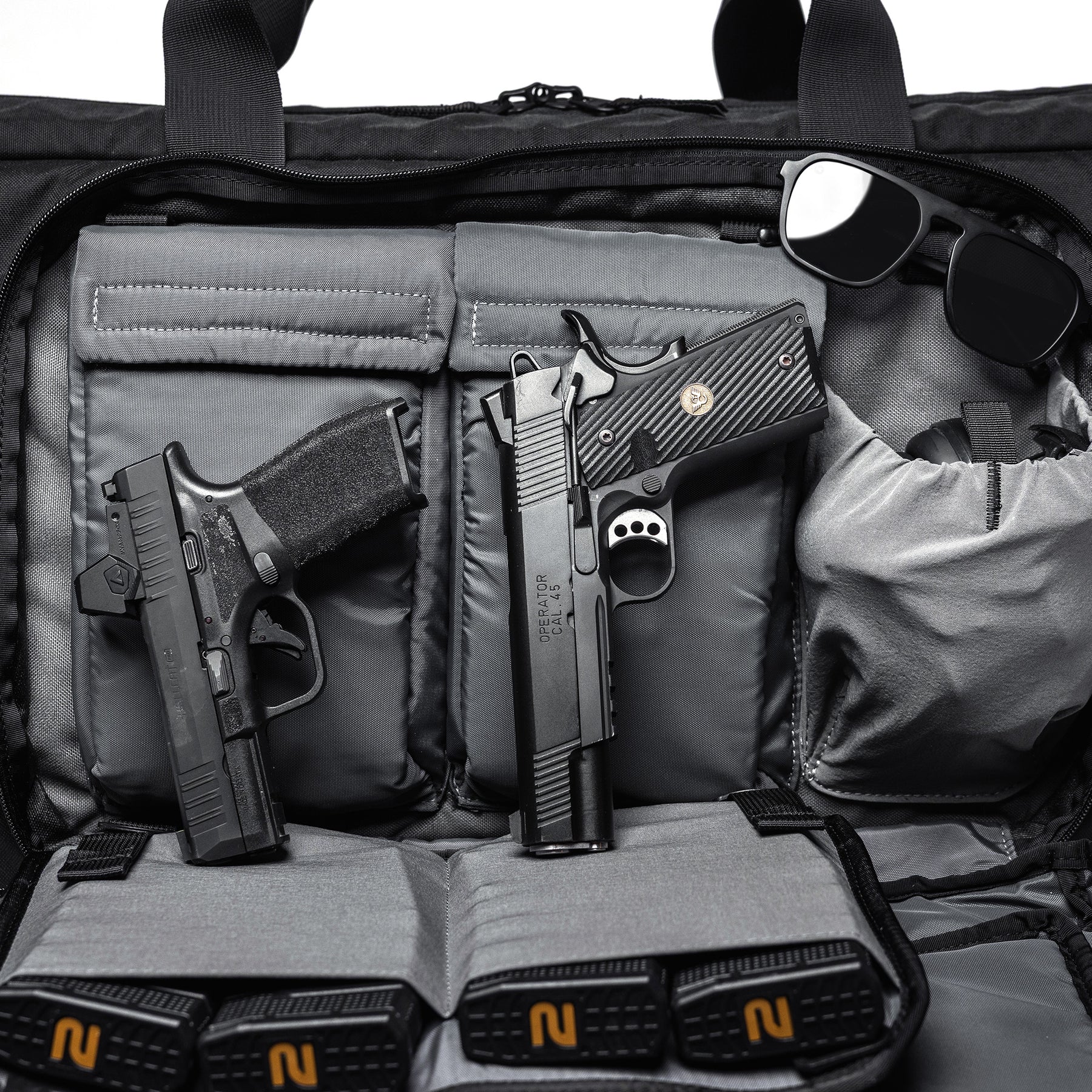 Black Lone Star 36" rifle bag with two handguns, sunglasses, and accessories inside, designed for firearm storage and transport.
