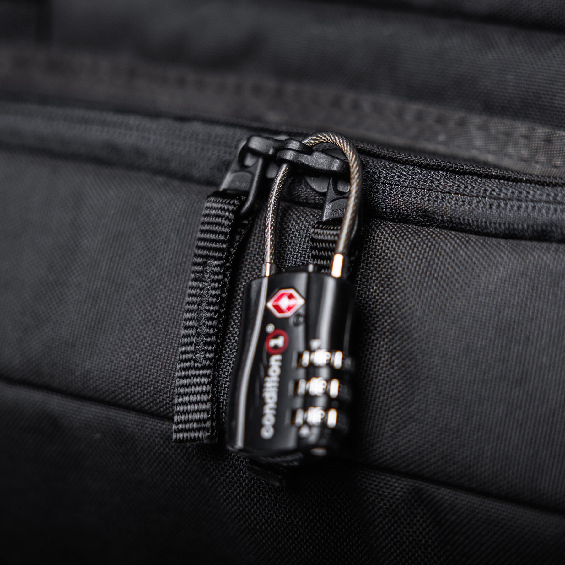 Close-up of a black combination lock securing a zipper on a 36-inch Lone Star rifle bag, made of durable fabric.