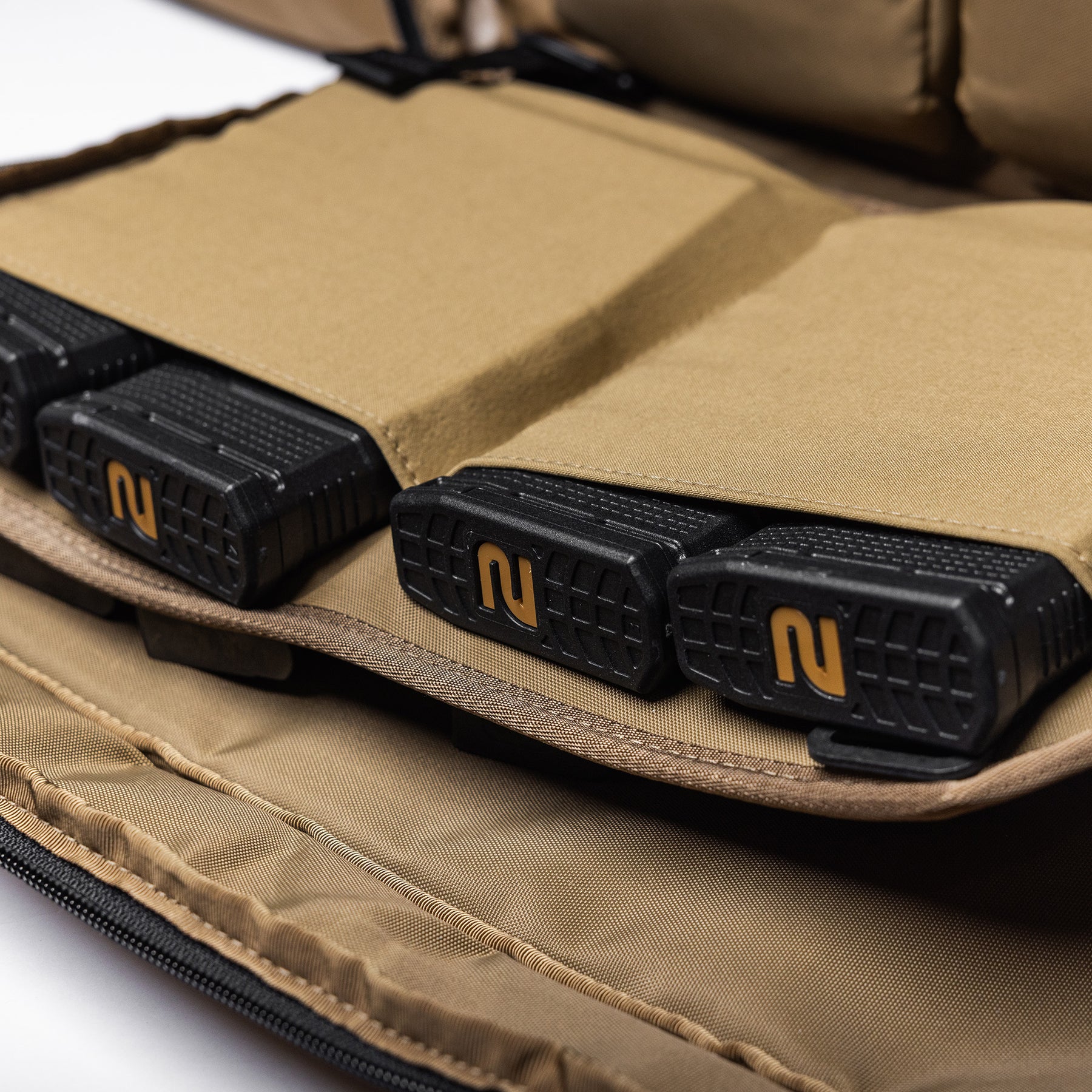 Close-up of a tan Lone Star 36" rifle bag with three black rubberized magazine pouches inside.