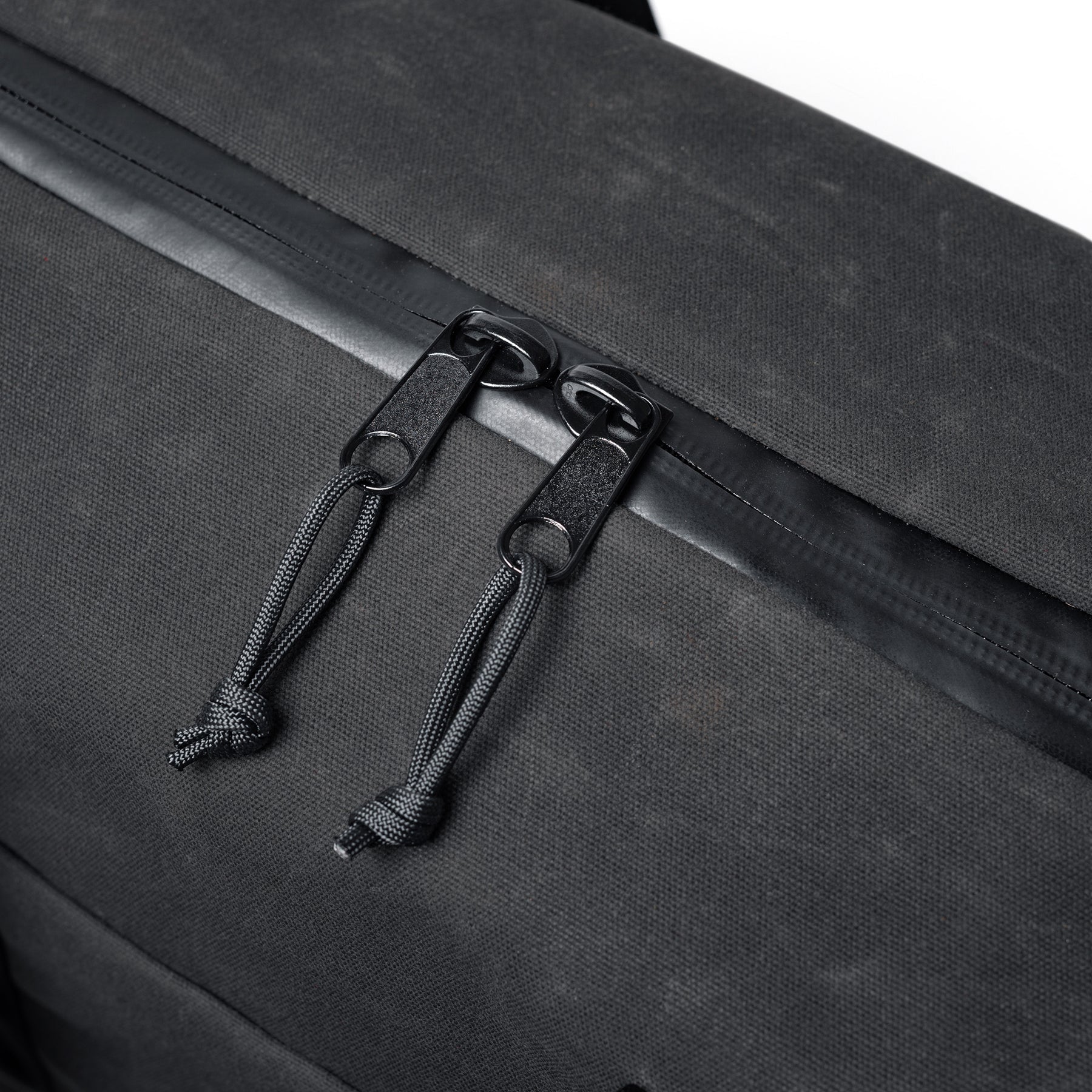 Close-up of the GOBAG Waxed Canvas Duffle with black zipper pulls and durable fabric, showcasing its rugged, stylish design.