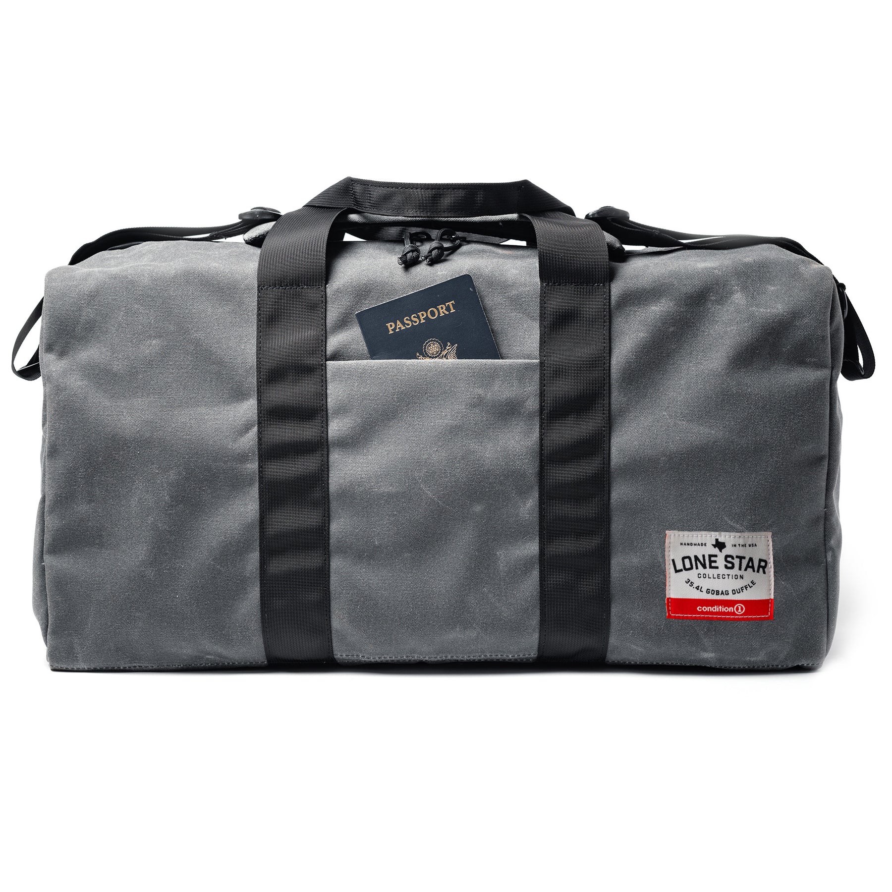 Gray waxed canvas duffle bag with black straps, front pocket, and a visible passport inside.
