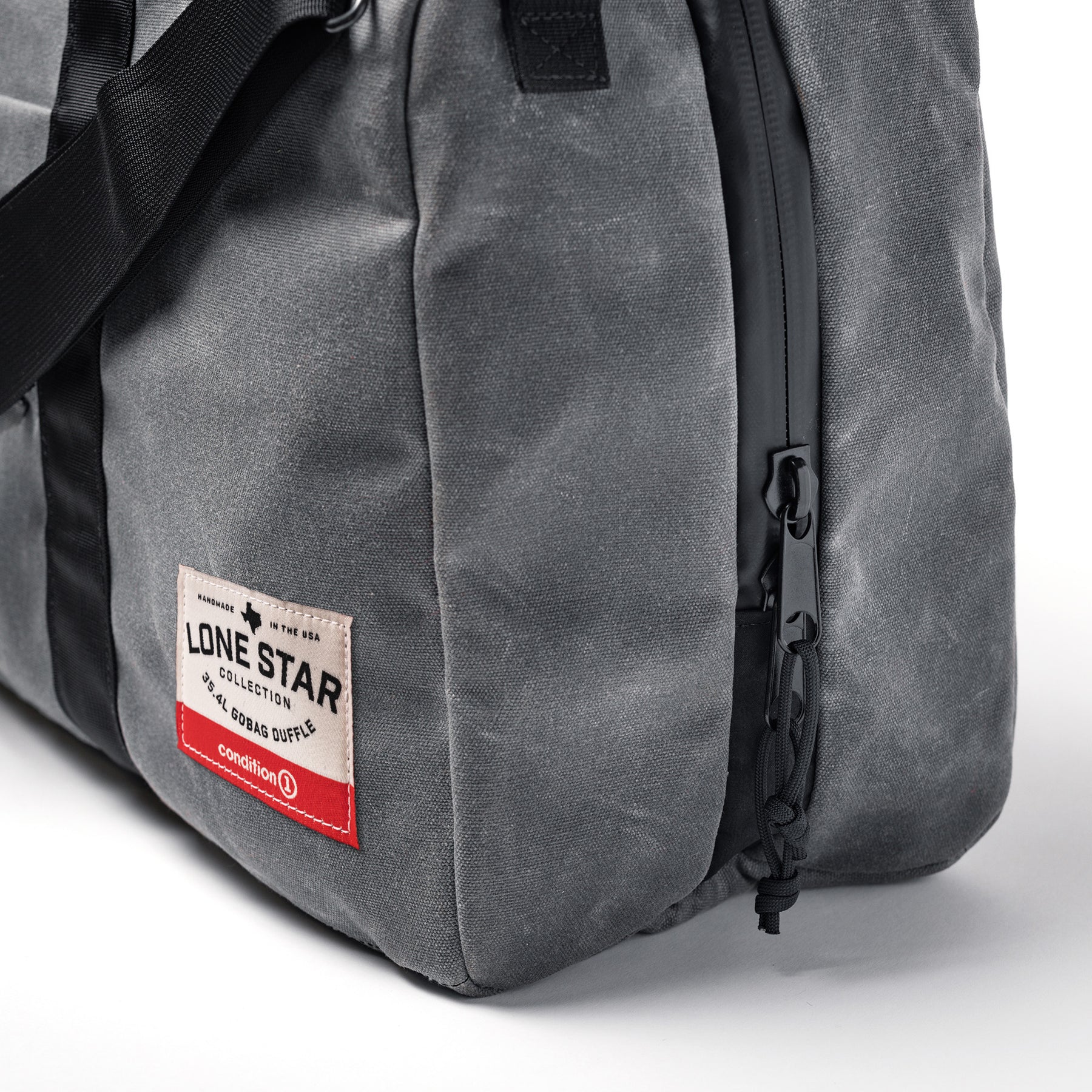 Gray waxed canvas duffle bag with black zipper, front pocket, and a label reading "Lone Star Collection, 35.4L GOBAG Duffle.