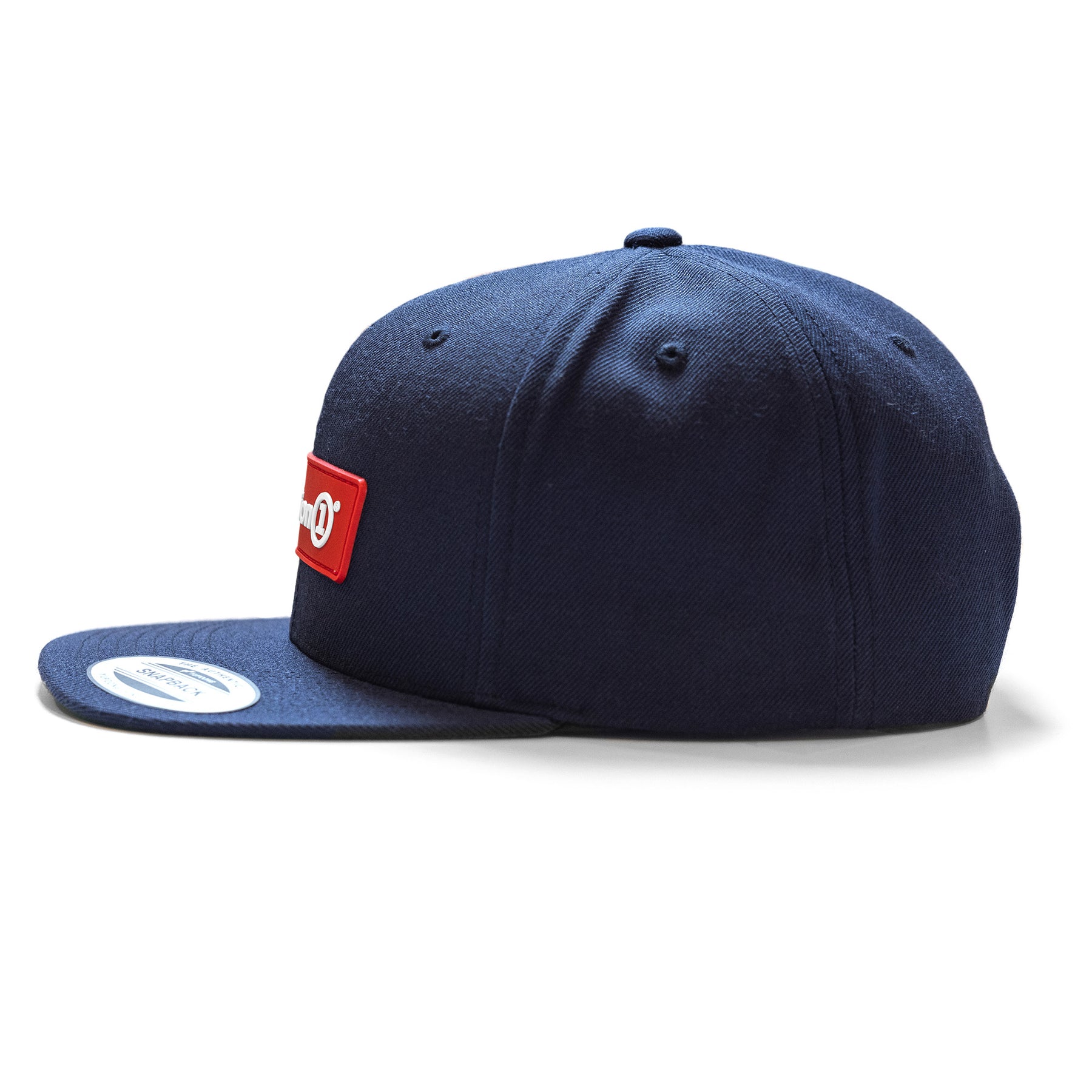Black snapback cap with a red rectangular patch on the front, featuring a white logo and a flat brim.