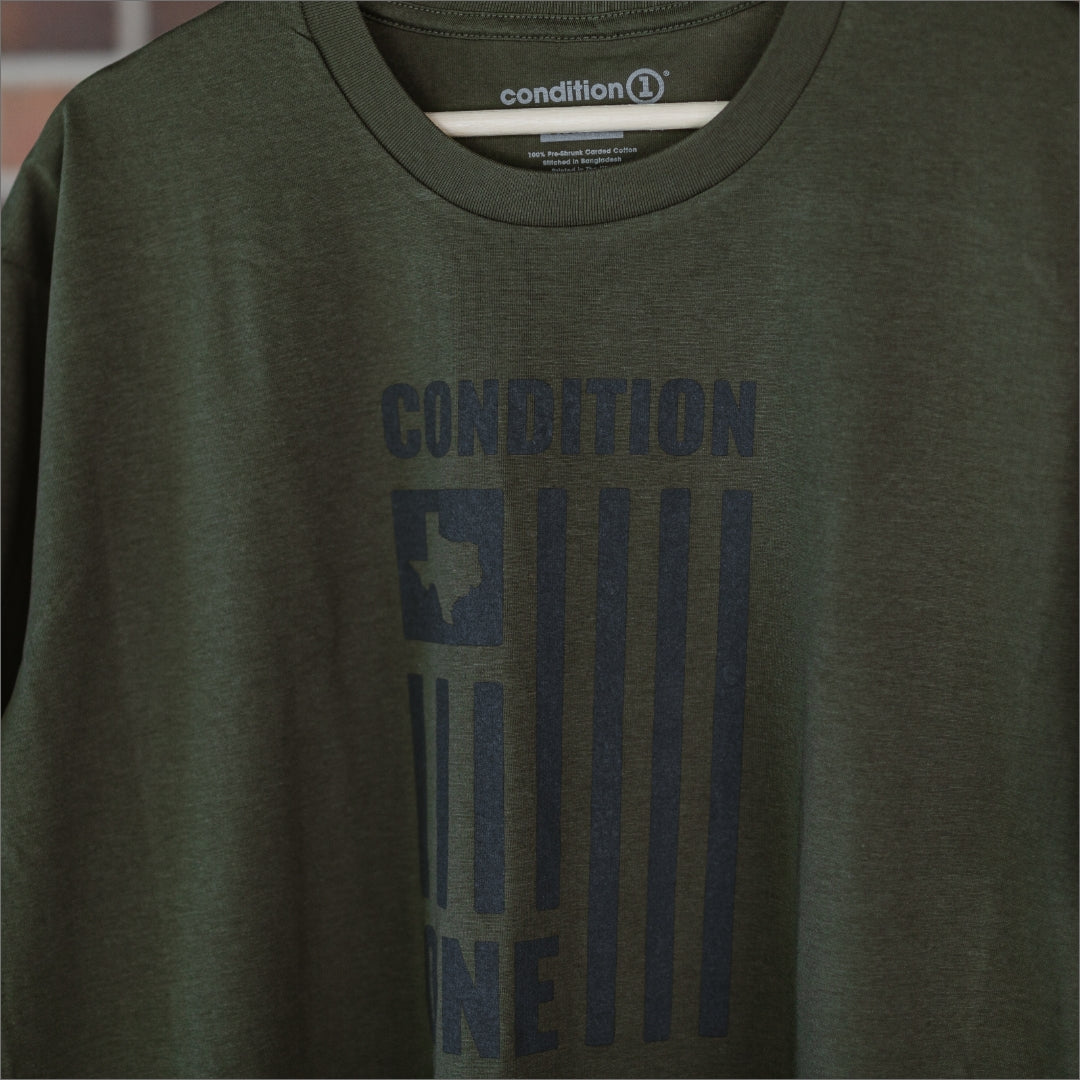 Green T-shirt with "Condition" text and a Texas-shaped flag graphic printed vertically on the front.