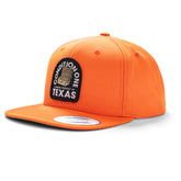 Orange snapback hat with "Texas Badass Hunter" patch, featuring a rugged design and curved brim.
