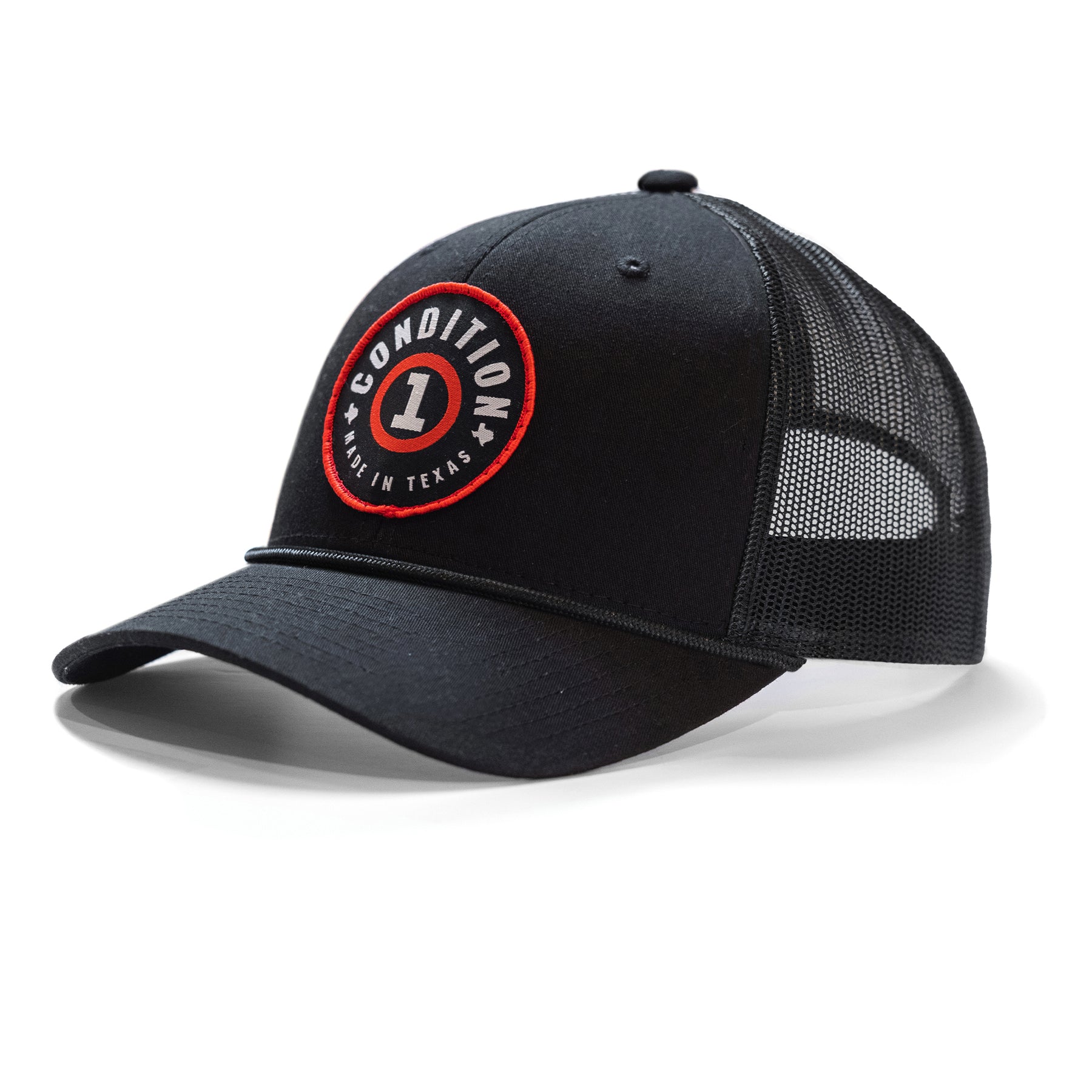 Black snapback hat with a red and white circular patch reading "Condition 1 Made in Texas" on the front, mesh back panels.