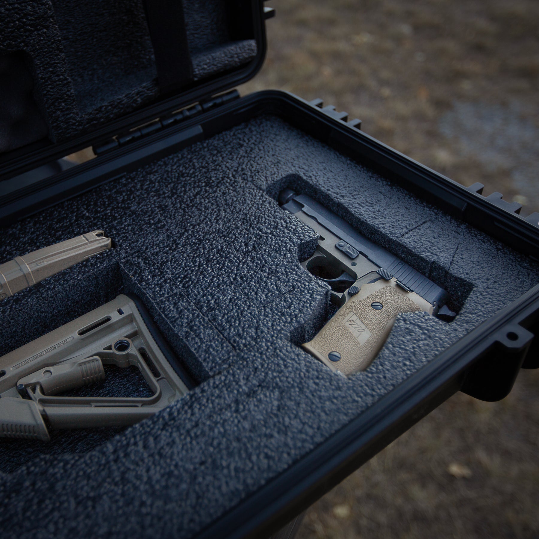 Black 55-inch gun case with foam interior, holding a handgun and accessories, designed for firearm storage and transport.