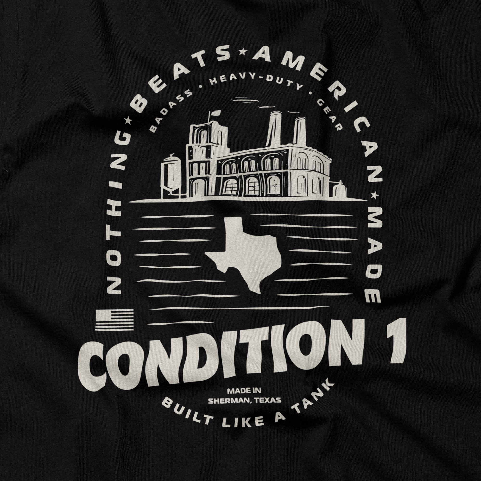 Black American-made T-shirt featuring a white graphic of a factory, Texas outline, and text emphasizing quality and durability.