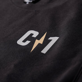 Close-up of a black crew sweatshirt featuring a prominent C1 logo with a lightning bolt design in gold and white.