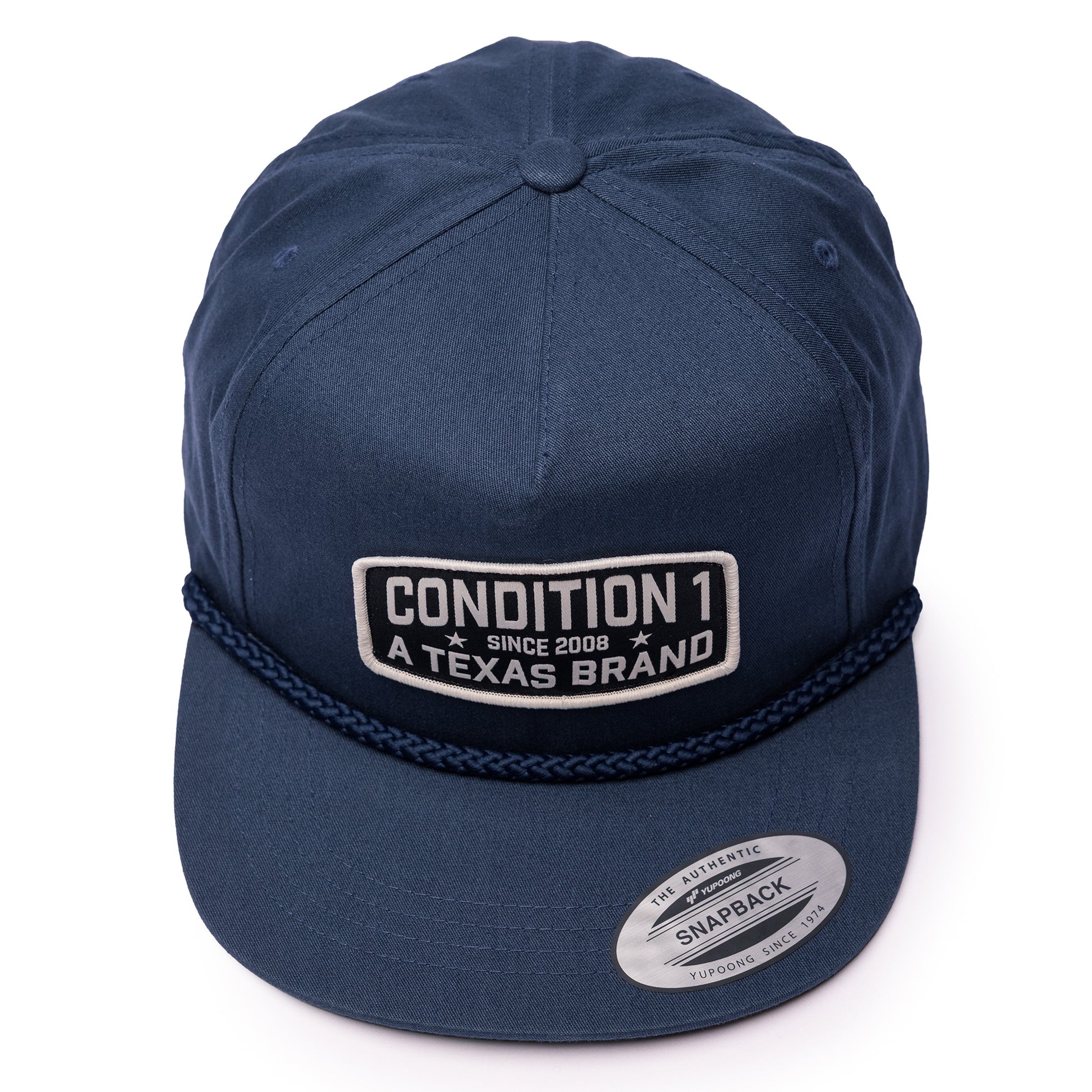 Navy unstructured snapback cap featuring a stitched logo patch that reads "Condition 1 Since 2008 A Texas Brand.