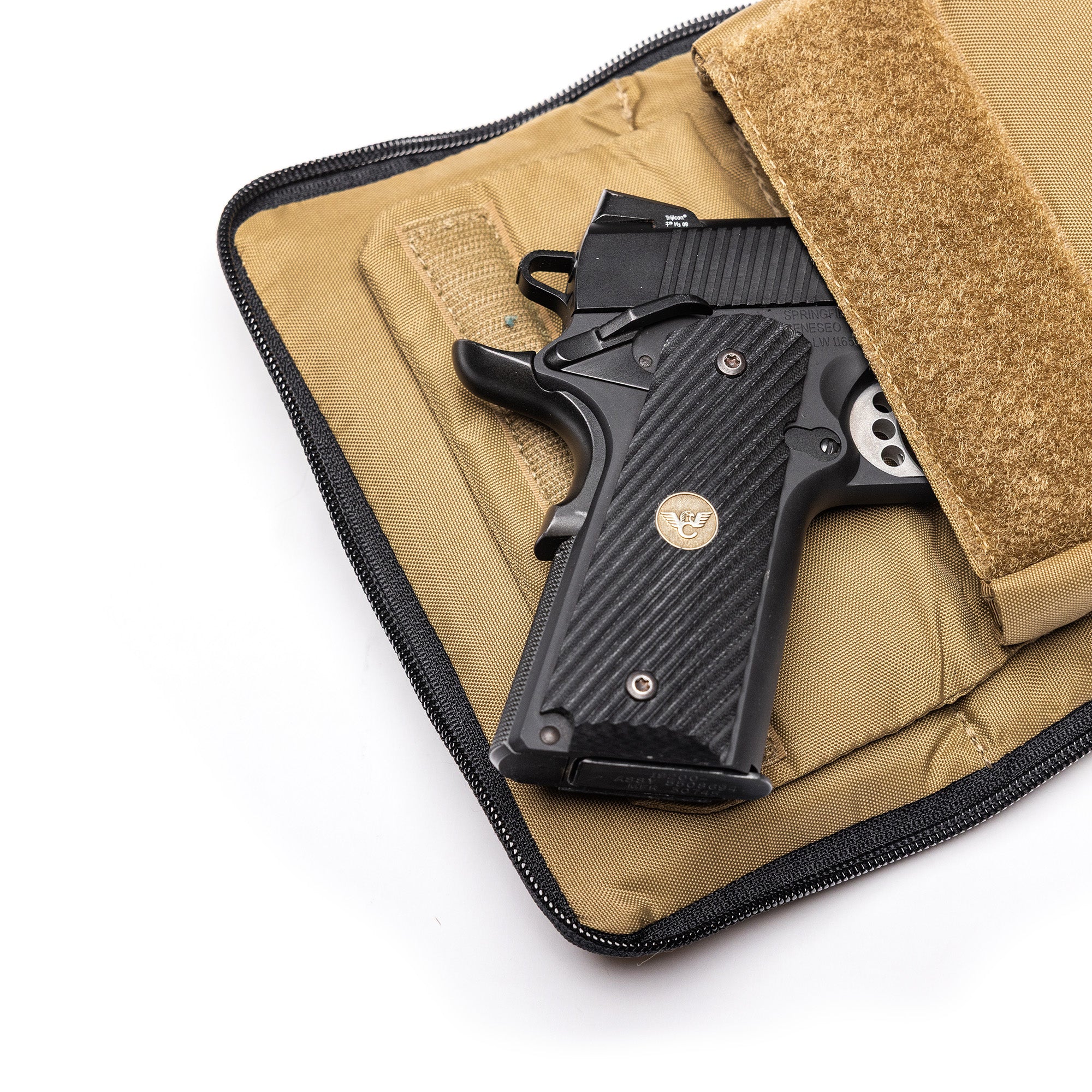 Black Lone Star 2 pistol bag with a textured grip, partially open, inside a tan protective case with a Velcro strap.