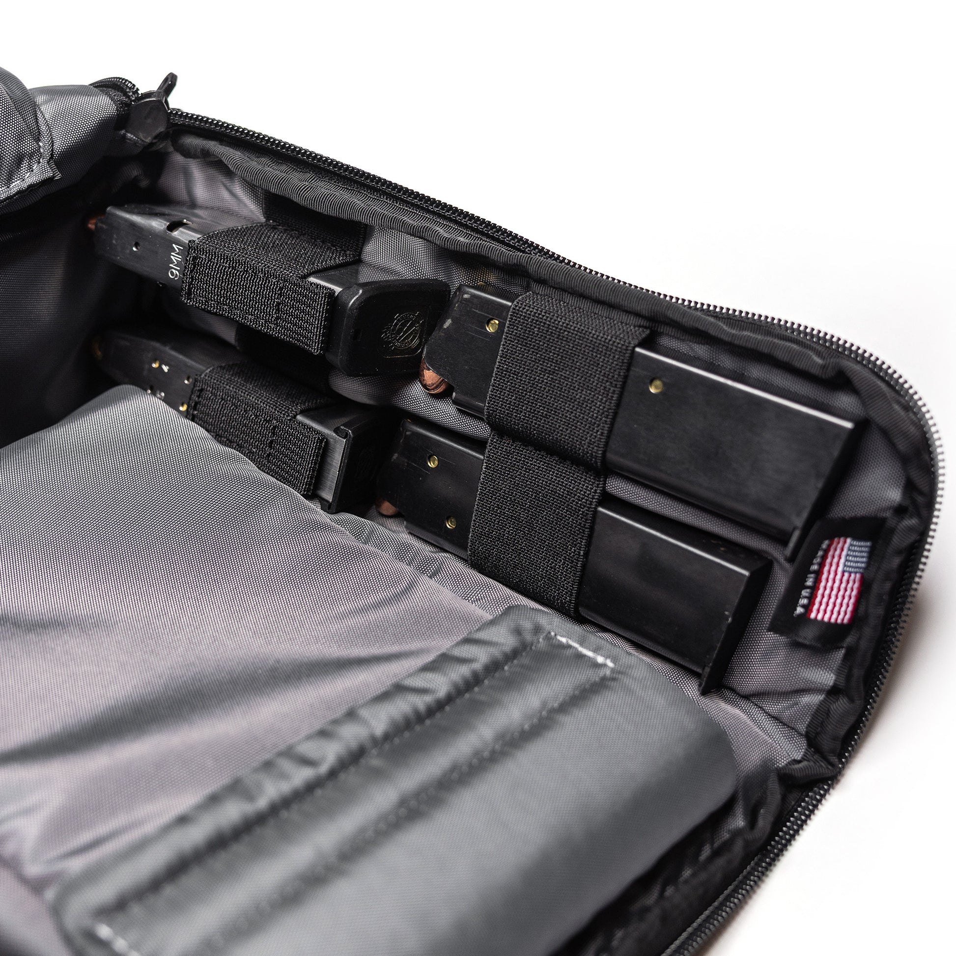 Inside of a Lone Star 2 Pistol Bag showing multiple black pistol magazines secured with elastic straps and compartments.