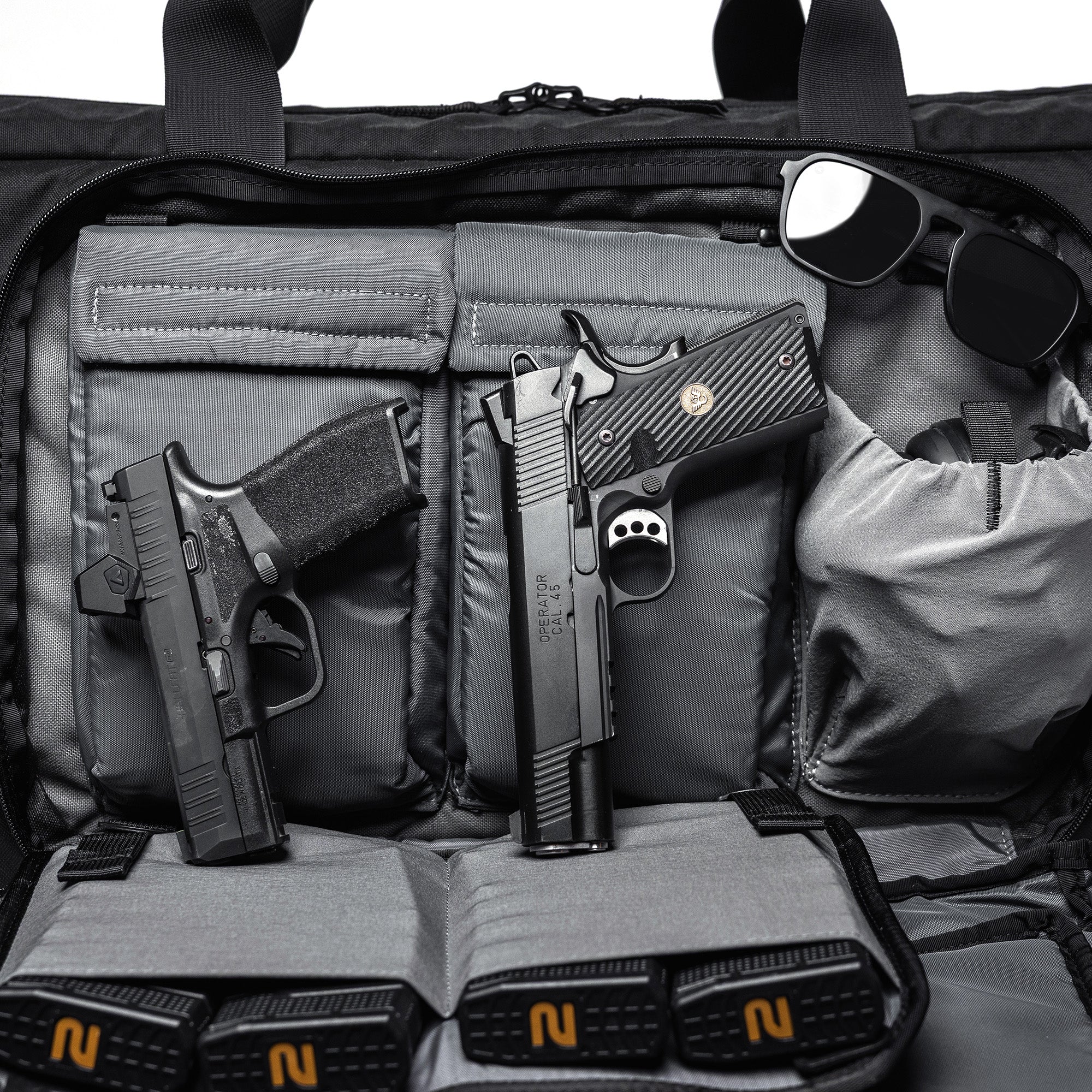 Black Lone Star 36" rifle bag with two handguns, sunglasses, and accessories inside, designed for firearm storage and transport.