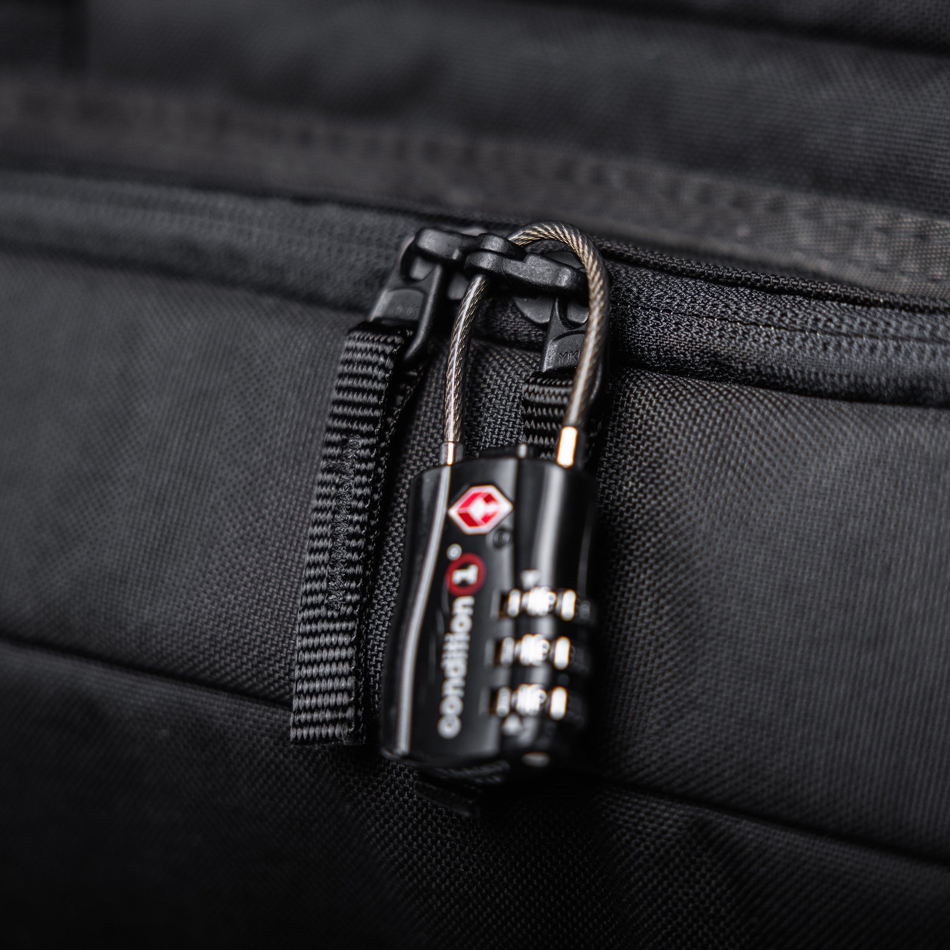 Close-up of a black combination lock securing a zipper on a 36-inch Lone Star rifle bag, made of durable fabric.