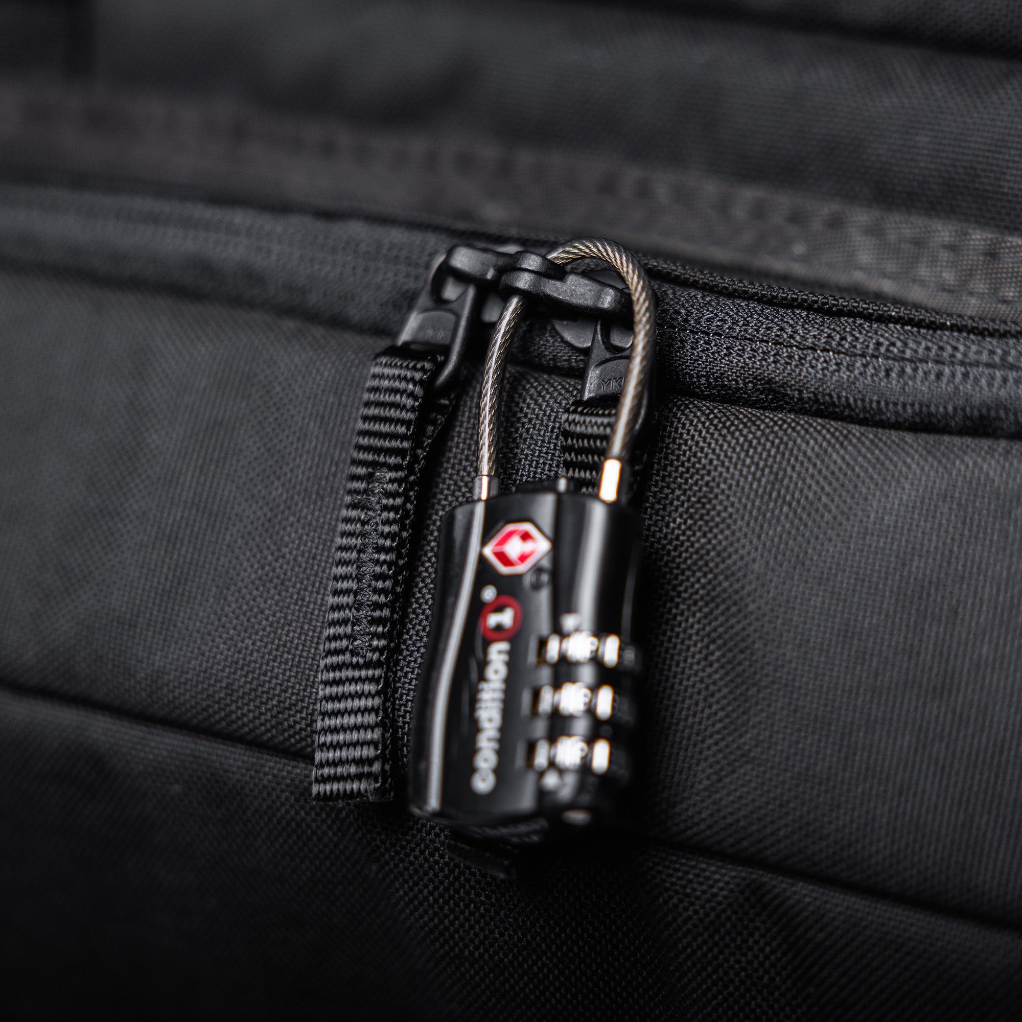 Close-up of a black combination lock securing a zipper on a 36-inch Lone Star rifle bag, made of durable fabric.