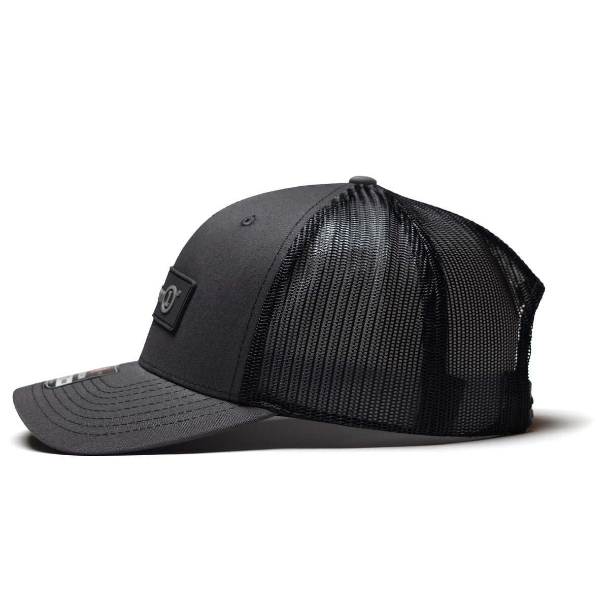 Black snapback cap with a curved brim and mesh back panel, featuring a Defender logo patch on the front.