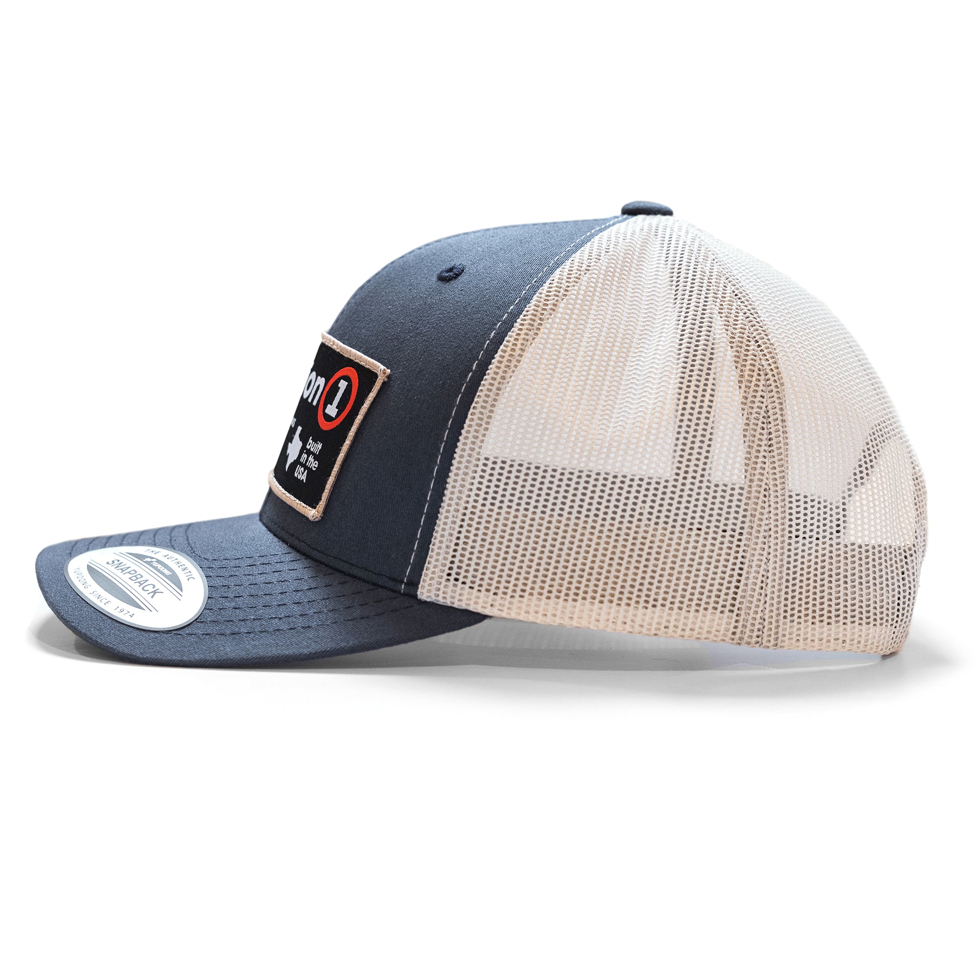 The Label snapback hat with a navy front, beige mesh back, and a patch reading "on 1" on the front panel.